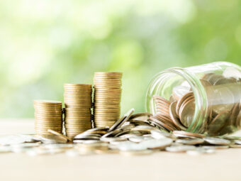 Coin on wooden table in front of green bokeh background.