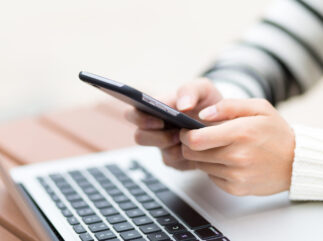 Woman use of mobile phone with laptop computer
